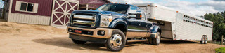 Heavy-duty commercial truck utilizing an underbed CURT gooseneck hitch system to safely tow a loaded flatbed trailer